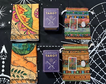 May include: An assortment of tarot-related items on a black background with a white geometric design. Includes two decks of "Everyday Tarot" cards, two patterned fabric pouches with crystals, and two matching tarot cloths with colorful illustrations.