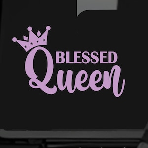 May include: Pink vinyl decal with a crown and the text "Blessed Queen" on a black background. The decal is on the back of a black vehicle.
