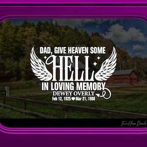 May include: A white decal with the text "DAD, GIVE HEAVEN SOME HELL IN LOVING MEMORY" and the name "DEWEY OVERLY" with dates. The design includes angel wings and is set against a scenic background.