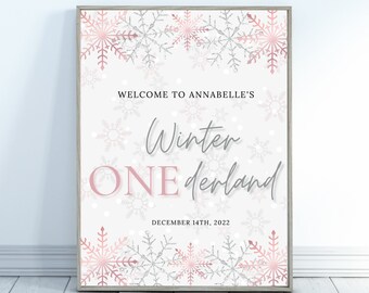 以下が含まれることがあります： 冬をテーマにした額入りのサイン。サインには「Welcome to Annabelle's Winter ONE derland」と2022年12月14日の日付が書かれています。デザインは、白地の背景にピンクとシルバーの雪の結晶が特徴です。
