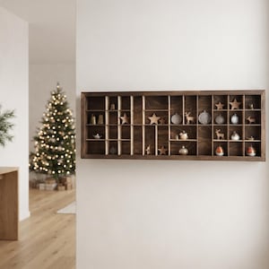 May include: A rectangular dark brown wooden wall shelf with multiple small square and rectangular compartments. The shelf contains various small decorative items, including stars, animal figures, and round ornaments arranged in the grid.