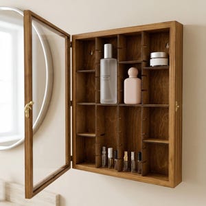 May include: A wooden wall cabinet with a glass door, open to show multiple shelves. The cabinet contains various cosmetic products, including bottles and jars. The cabinet is made of stained wood and is mounted on a light-coloured wall.