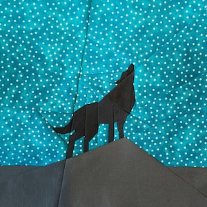 Puede incluir: Una silueta de lobo negra de papel aullando a la luna, sobre un fondo azul turquesa con lunares blancos.