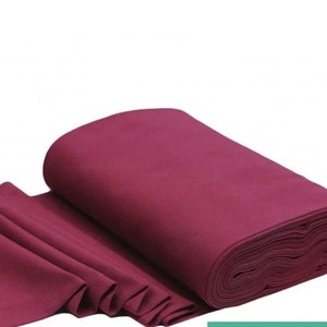 May include: A roll of deep burgundy fabric. The fabric is folded and rolled up, showing the texture of the material.