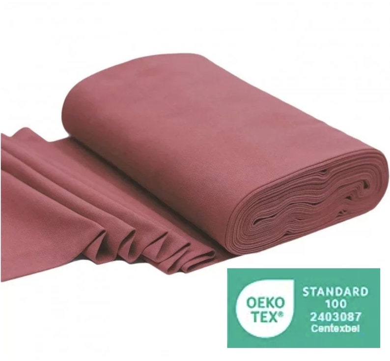 May include: A roll of deep rose colored fabric with the Oeko-Tex Standard 100 certification label. The label states "Standard 100 2403087  Contexbel".