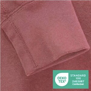 May include: Close-up of a burgundy colored fabric with a stitched seam. The fabric has a soft, textured surface. A green Oeko-Tex Standard 100 certification label is visible in the bottom right corner. The label has the text "OEKO-TEX&reg;" and "STANDARD 100" in white. The number "2403087" and the word "Centexbel" are also visible in white.