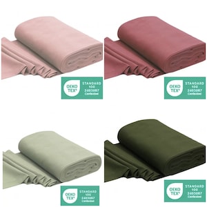 Könnte beinhalten: Vier Rollen Stoff in verschiedenen Farben: Altrosa, Rosa, Salbeigrün und Olivgrün. Jede Rolle hat ein grünes Etikett mit dem Text "OEKO-TEX® STANDARD 100 2403087 Centexbel".
