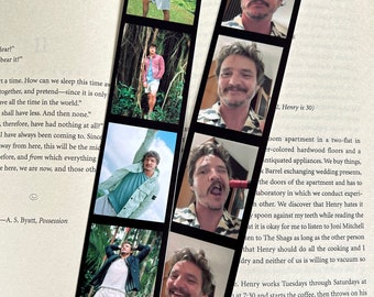 May include: A black and white photo strip bookmark with eight photos of a man with brown hair and a beard. The photos are arranged in two columns of four photos. The photos show the man in different poses and expressions. The bookmark is made of thick paper and has a black border.