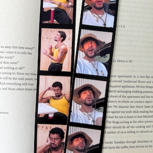 Könnte beinhalten: Zwei Lesezeichen mit einer Reihe von Bildern eines Mannes in verschiedenen Posen. Eines zeigt den Mann in einem gelben Tanktop, das andere mit Hut und weißem Hemd. Die Lesezeichen liegen auf einem Buch.