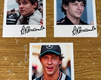 May include: Three polaroid-style photos featuring a young man. Each photo shows the man in different outfits and expressions. The photos are on a wooden surface, and each has a handwritten signature at the bottom. The man is wearing a hat in one photo.