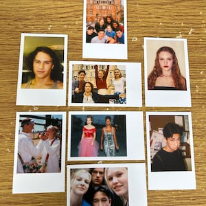 May include: A collection of nine Polaroid photos featuring a group of people, a building, and a variety of scenes. The photos are arranged in a grid pattern on a wooden surface.