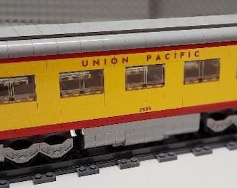 May include: A yellow and red LEGO train car with the words "UNION PACIFIC" printed on the side. The car has a number "3585" printed on the side.
