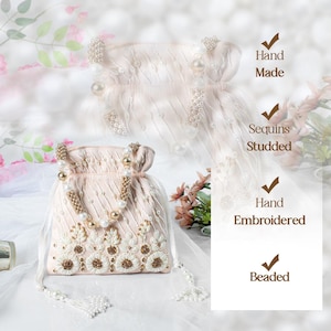 May include: A delicate, hand-beaded drawstring bag with a pearl and gold chain strap. The bag is made of a soft, pink fabric and features intricate floral embroidery. It is adorned with sequins and has a hand-embroidered design. "Hand Made", "Sequins Studded", "Hand Embroidered", and "Beaded" are written on the image.
