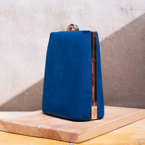 Navy blue suede clutch purse with a gold-tone chain, perfect for elegant evening events.