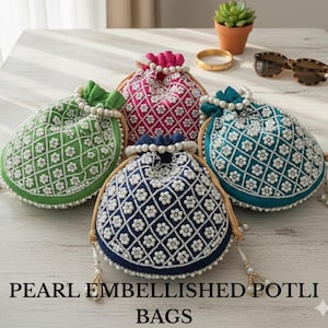 May include: A collection of five colorful potli bags, each adorned with intricate white pearl embellishments. The bags feature a variety of colors, including green, pink, blue, and teal, with a drawstring closure and a beaded handle. The bags are displayed on a light-colored surface.