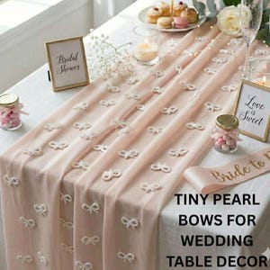 Pearlized bow charms sophisticated reception tabletop,pearl and prosciutto decoration ideas,  "Pearls and Prosecco" theme.