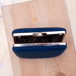 Stylish navy evening bag featuring a soft suede texture and detachable gold chain strap.