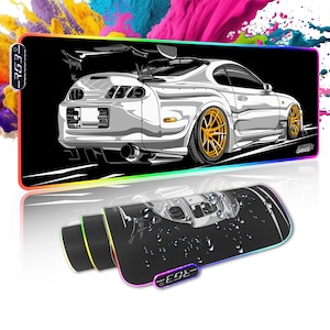 Könnte beinhalten: Eine Schwarzweißillustration eines weißen Sportwagens mit einem schwarzen Spoiler auf schwarzem Hintergrund. Das Auto befindet sich auf einer schwarzen und weißen Gaming-Mausmatte mit einem regenbogenfarbenen LED-Lichtrahmen. Die Mausmatte trägt den Text "Garage" in der unteren rechten Ecke.