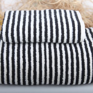 May include: Two black and white striped towels stacked on top of each other. The towels are made of a soft, absorbent material.