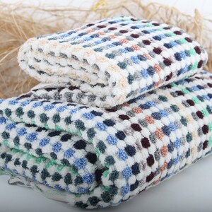 May include: Two folded towels with a checkered pattern in shades of white, blue, green, and brown.