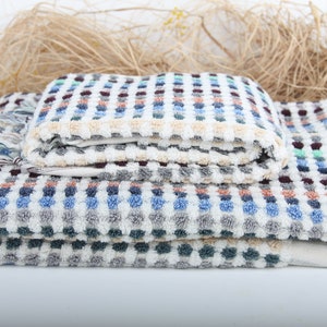 May include: A stack of four colorful towels with a checkered pattern. The towels are made of soft, absorbent cotton and are perfect for drying off after a shower or bath.