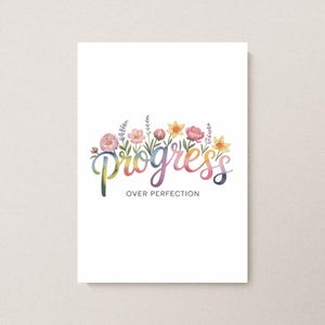 Puede incluir: Una tarjeta blanca con la palabra "Progress" en escritura colorida, sobre las palabras "Over Perfection". El texto está acentuado por un borde floral de acuarela con flores rosas, amarillas y moradas y hojas verdes.