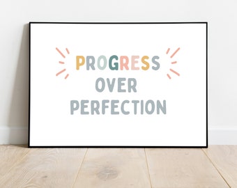 May include: A framed print with the text "PROGRESS OVER PERFECTION" in colorful letters. The text is surrounded by stylized sunbursts.