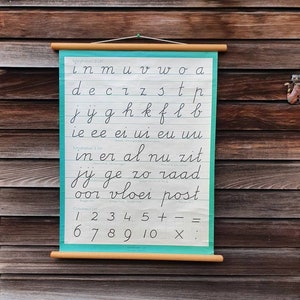May include: A vintage educational chart with a turquoise background. The chart features the alphabet in cursive handwriting, followed by common words and numbers 1-10. The chart is mounted on a wooden dowel rod.