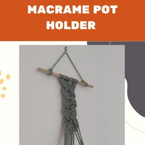 May include: A macrame plant hanger with a wooden dowel and a clear glass vase. The hanger is made with a light green cord and is hanging from a hook on a white wall.