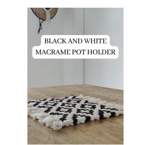 May include: Black and white macrame pot holder with a geometric pattern. The pot holder is made with cotton cord and has a fringe border. "KRIFTS.ETSY.COM" is written below the pot holder.