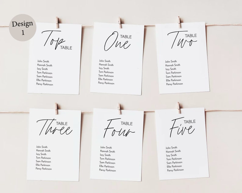 Peut inclure: Cinq cartes blanches avec du texte noir, chacune &eacute;tiquet&eacute;e avec un num&eacute;ro de table&nbsp;: Top, One, Two, Three, Four et Five. Chaque carte liste les noms des invit&eacute;s assign&eacute;s &agrave; cette table.