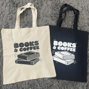 以下が含まれることがあります： 黒と白で「Books & Coffee」と印刷されたトートバッグ2つ。バッグはキャンバス製で、黒いハンドルが付いています。