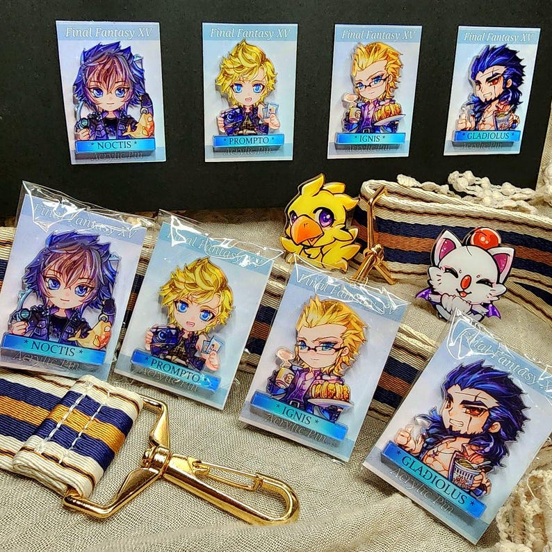 May include: A collection of Final Fantasy XV acrylic pins featuring characters Noctis, Prompto, Ignis, and Gladiolus. Each pin is a colorful illustration of the characters. Also included are a Chocobo and a Moogle pin.