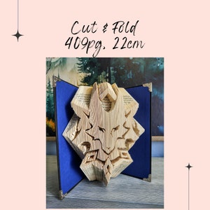 May include: A book with 409 pages has been cut and folded into a 3D sculpture of a wolf's head. The sculpture is 22 cm tall and is displayed on a blue background.