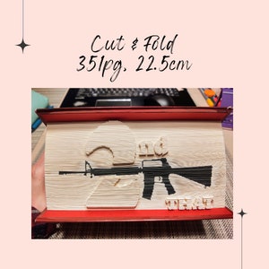 May include: A book with 351 pages, measuring 22.5 inches, folded into a 3D sculpture of a rifle and the number "2" with the word "and" above it and the word "that" below it.