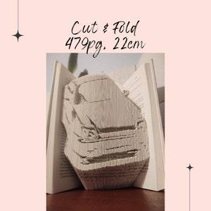 May include: A book with 479 pages has been folded into a 3D sculpture of a car. The book is 22 cm tall.  Cut & Fold 479pg. 22cm is written on the image.