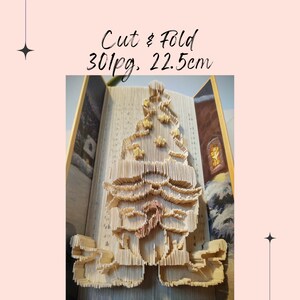 Puede incluir: Un árbol de Navidad 3D de papel hecho de un libro de 30 páginas. El árbol mide 22,5 cm de alto y está hecho de páginas dobladas.