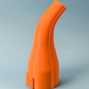 Puede incluir: Boquilla curva de color naranja brillante con una base texturizada. La boquilla tiene una forma suave y redondeada y se estrecha hacia la parte superior. La base presenta una peque&ntilde;a secci&oacute;n rectangular con un borde estriado. El objeto est&aacute; sobre un fondo azul claro.