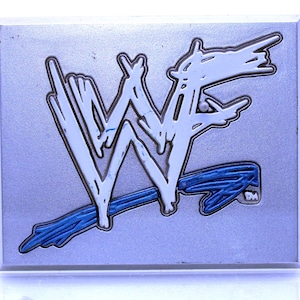 Könnte beinhalten: Eine silberne Plakette mit einem stilisierten "WF"-Logo in Weiß und Blau. Das Logo ist blau umrandet und hat einen weißen Hintergrund.
