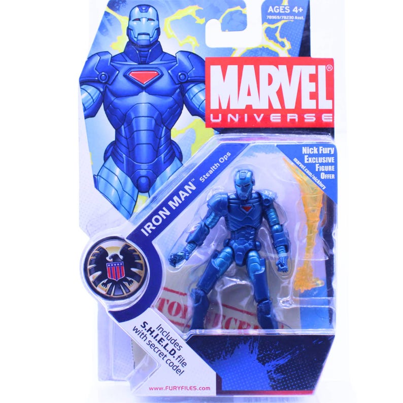 K&ouml;nnte beinhalten: Blaue Iron Man Actionfigur aus dem Marvel-Universum, verpackt mit einer Karte mit dem Marvel-Logo und dem Text "Iron Man Stealth Ops". Die Verpackung enth&auml;lt eine S.H.I.E.L.D.-Datei mit einem Geheimcode und ist f&uuml;r Kinder ab 4 Jahren geeignet.
