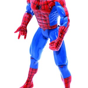 May include: A red and blue plastic action figure of Spider-Man. The figure has a web design on its suit and is posed in a fighting stance.