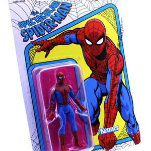Pu&ograve; includere: Una action figure in stile vintage di Spider-Man con un costume rosso e blu, confezionata in una confezione blister in plastica con sfondo giallo e rosso. La confezione presenta il logo Marvel Legends e il testo "The Spectacular Spider-Man".