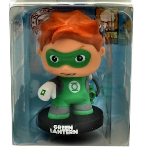 Op de afbeelding: Een klein plastic beeldje van Green Lantern in een doorzichtige plastic display. Het beeldje is groen en grijs met een zwarte basis. Op de basis staat "Green Lantern" gedrukt.