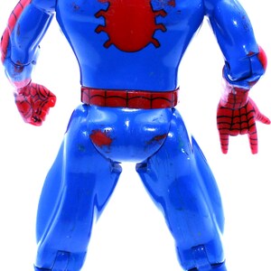 May include: A red and blue plastic action figure of Spider-Man. The figure is posed with its arms outstretched and its legs spread apart. The figure has a red spider symbol on its chest and a red and blue spider web pattern on its suit.