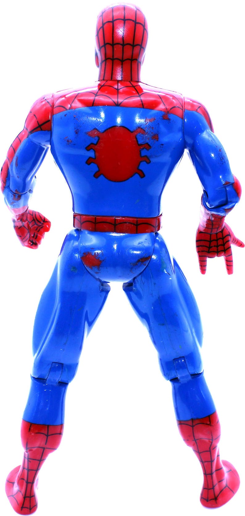 May include: A red and blue plastic action figure of Spider-Man. The figure is posed with its arms outstretched and its legs spread apart. The figure has a red spider symbol on its chest and a red and blue spider web pattern on its suit.
