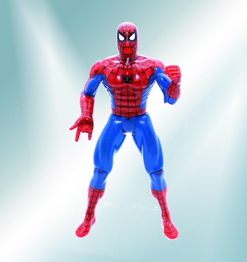 May include: A red and blue plastic action figure of Spider-Man. The figure is posed with its arms outstretched and its fists clenched.