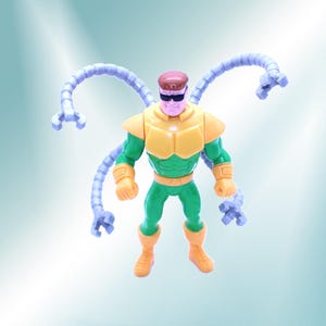 May include: A Dr. Octopus action figure. The figure is wearing a yellow and green outfit with four articulated, light purple mechanical arms. The figure has a brown head and black sunglasses. The figure is standing.