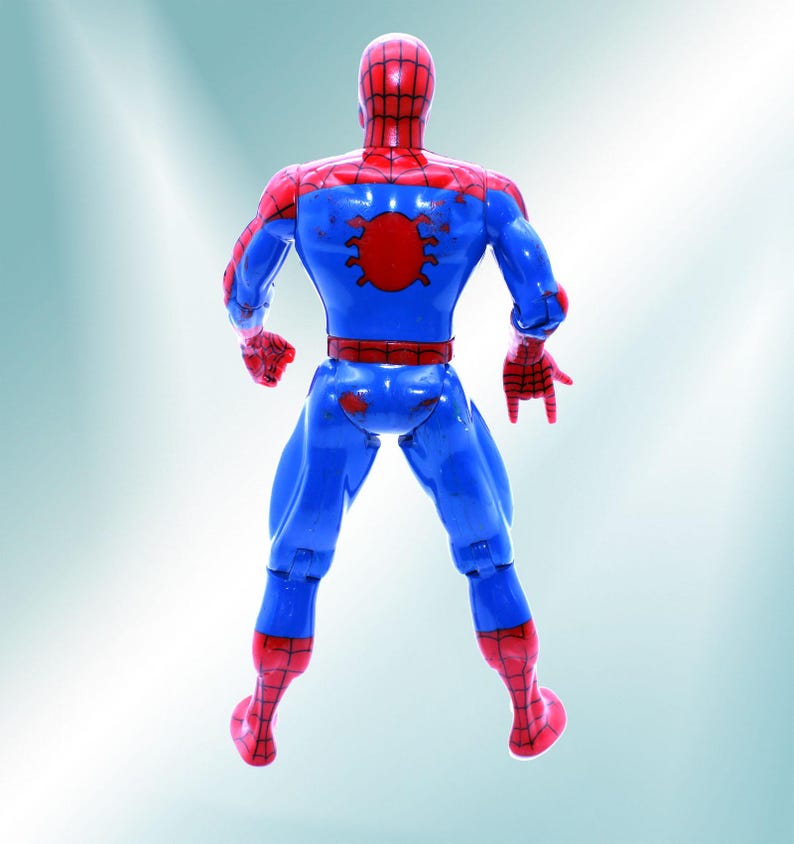 May include: A blue and red plastic action figure of Spiderman standing with his back to the camera. The figure has a red spider symbol on its back.