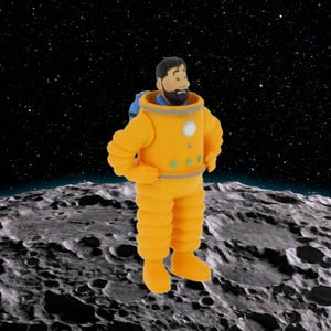 Könnte beinhalten: Figur eines Mannes in einem orangefarbenen Raumanzug, der auf einer grauen Mondoberfläche steht. Der Raumanzug hat einen blauen Kragen und einen kleinen blauen Rucksack. Der Hintergrund ist ein Sternenhimmel.