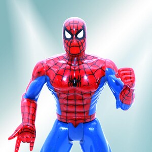 May include: A red and blue plastic action figure of Spider-Man with a black spider symbol on the chest. The figure has a white mask with black eyes and a red mouth.